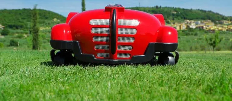 Front view of a red robotic lawn mower designed with a classic car grille aesthetic.