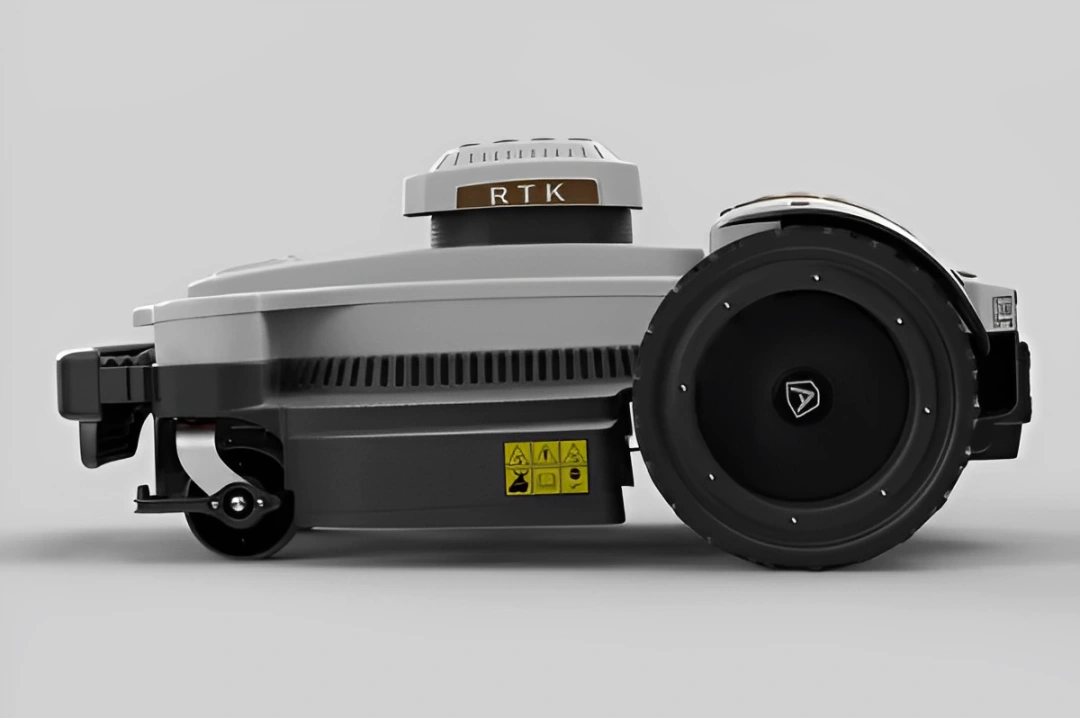 Side view of a gray RTK-enabled robotic mower with large wheels and safety labels.